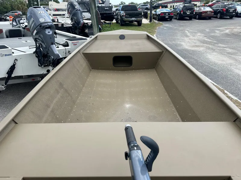 Slide: The Image of 2023 G3 1652 VBW boat, interior view, parked in a lot with other boats and vehicles. - 6