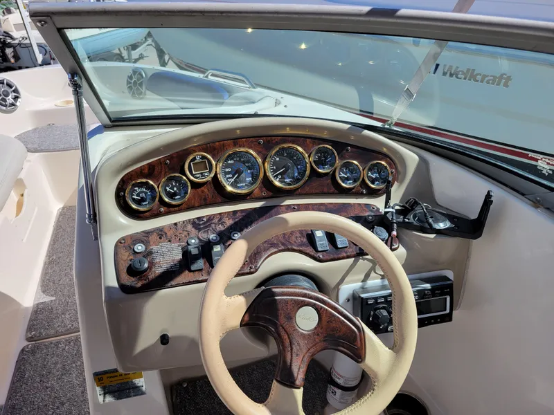 Slide: The Image of 2002 Rinker 212 BR boat dashboard with steering wheel and instrument panel. - 10