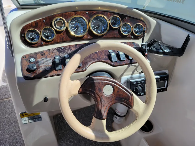 Slide: The Image of 2002 Rinker 212 BR boat dashboard with steering wheel and instrument panel. - 11