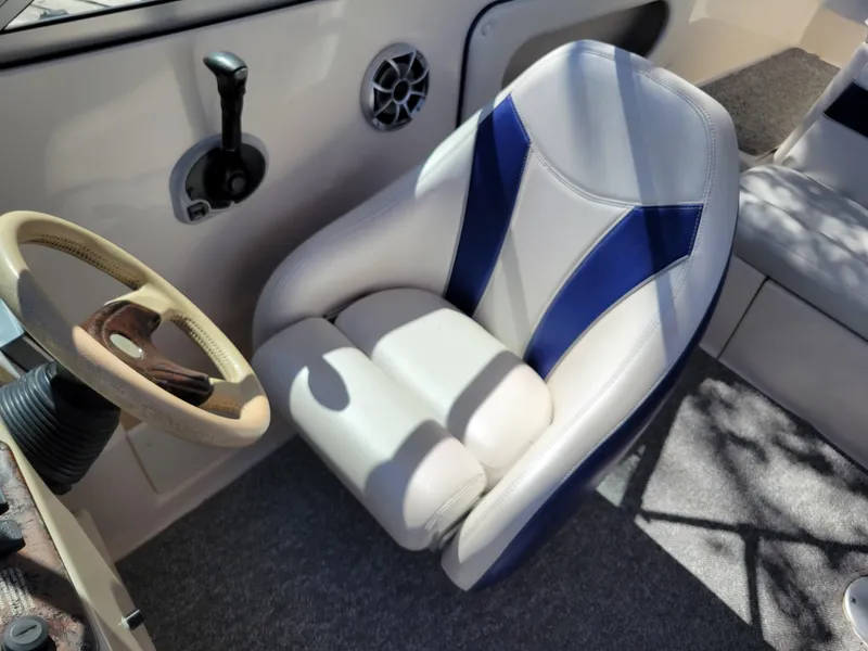 Slide: The Image of Captain's seat and steering wheel of a 2002 Rinker 212 BR boat. - 13