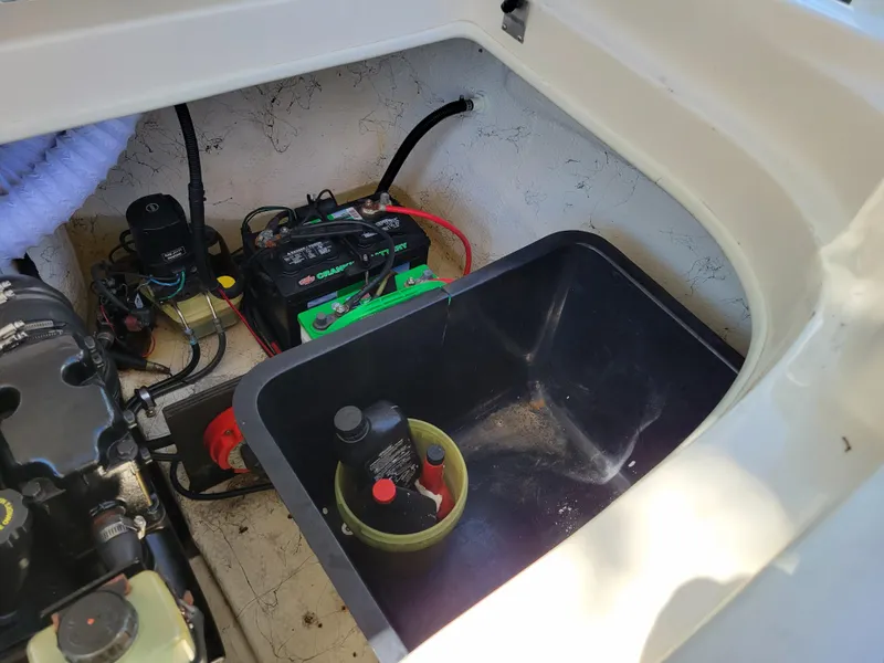 Slide: The Image of 2002 Rinker 212 BR boat engine compartment with battery and components. - 14