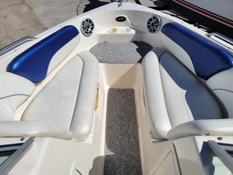 Slide: The Image of 2002 Rinker 212 BR boat interior with white and blue seating. - 16
