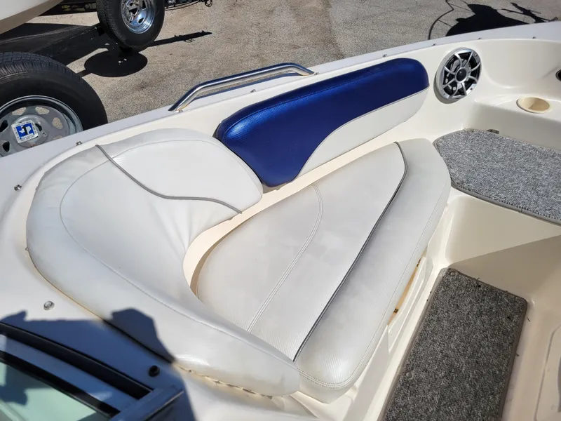 Slide: The Image of 2002 Rinker 212 BR boat interior seating with white and blue upholstery. - 17