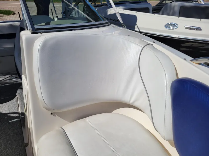Slide: The Image of 2002 Rinker 212 BR boat interior with white and blue seating. - 20