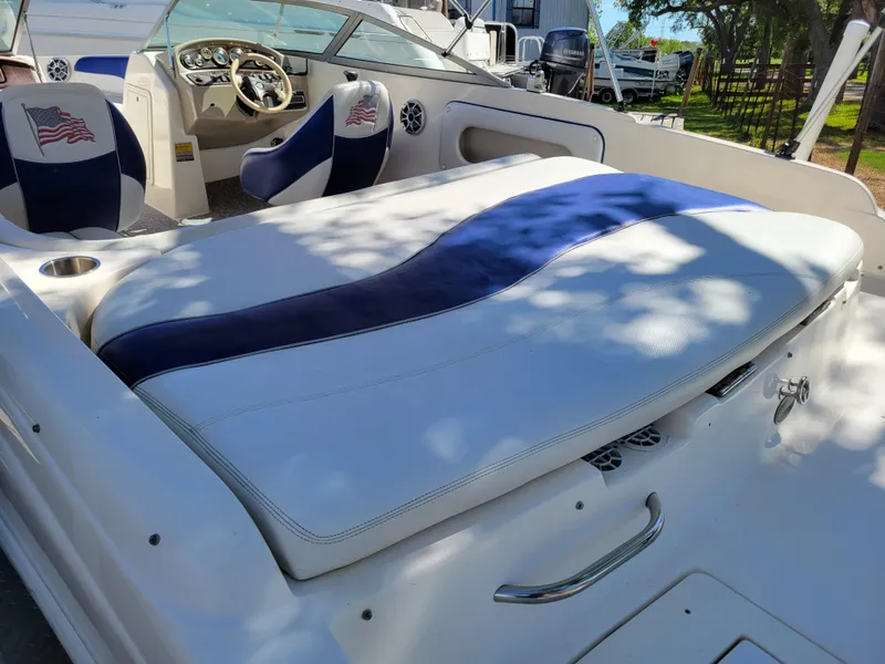 Slide: The Image of 2002 Rinker 212 BR boat interior with cushioned seating and steering console. - 4
