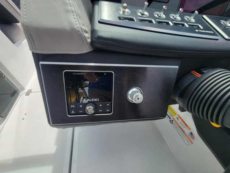 Slide: The Image of 2024 Four Winns H4 OB boat dashboard with audio control panel. - 15