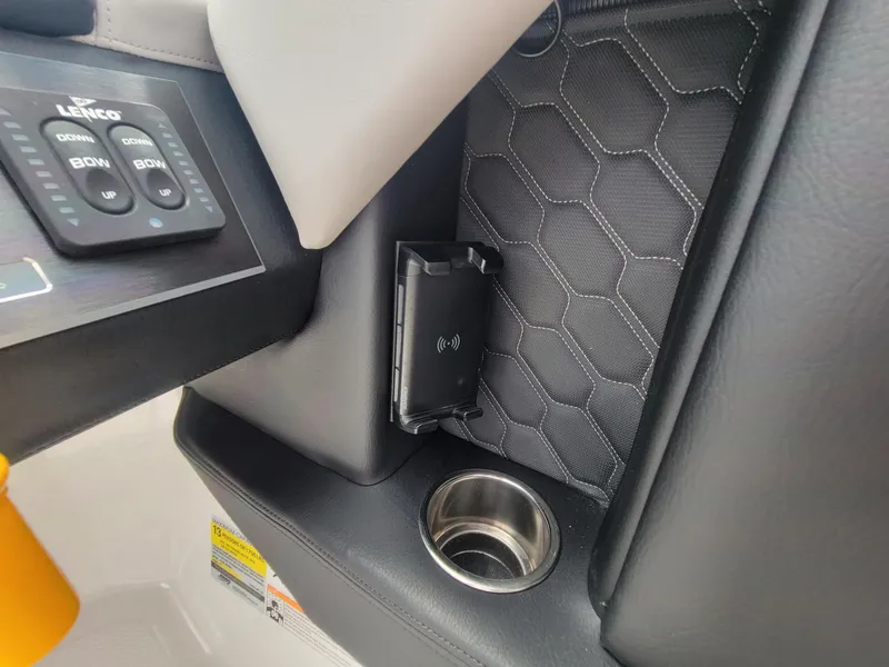 Slide: The Image of 2024 Four Winns H4 OB boat interior with control panel, cup holder, and phone holder. - 16