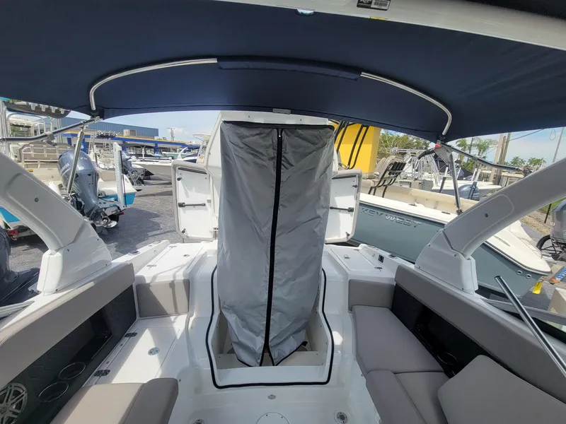 Slide: The Image of 2024 Four Winns H4 OB boat interior with covered center console and seating. - 19