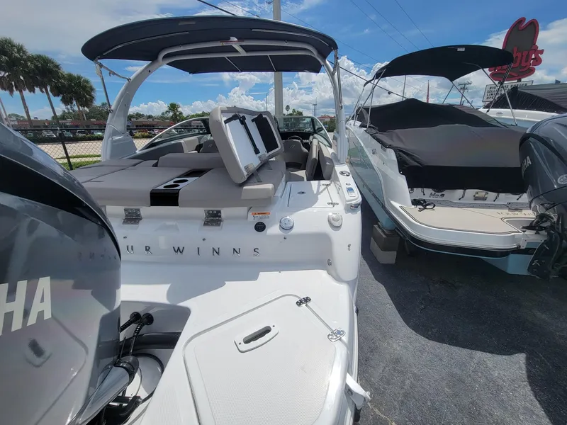 Slide: The Image of 2024 Four Winns H4 OB boat with Yamaha outboard motor, docked under a clear sky. - 8