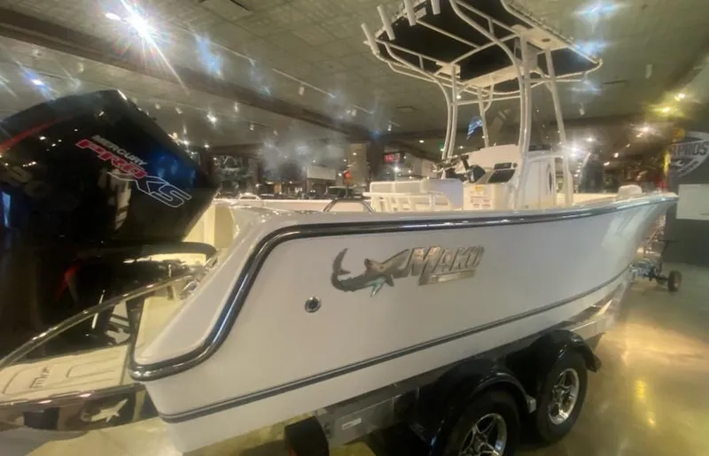 Slide: The Image of 2024 Mako 214 CC center console boat on display with dual-axle trailer. - 2