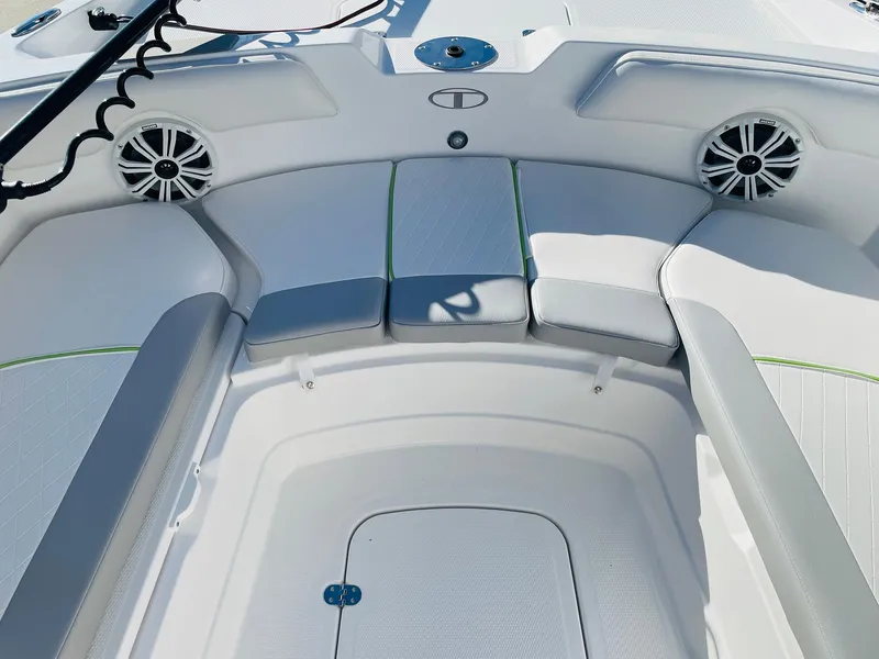 Slide: The Image of 2024 Tahoe 2150 CC boat interior with cushioned seating and speakers. - 10