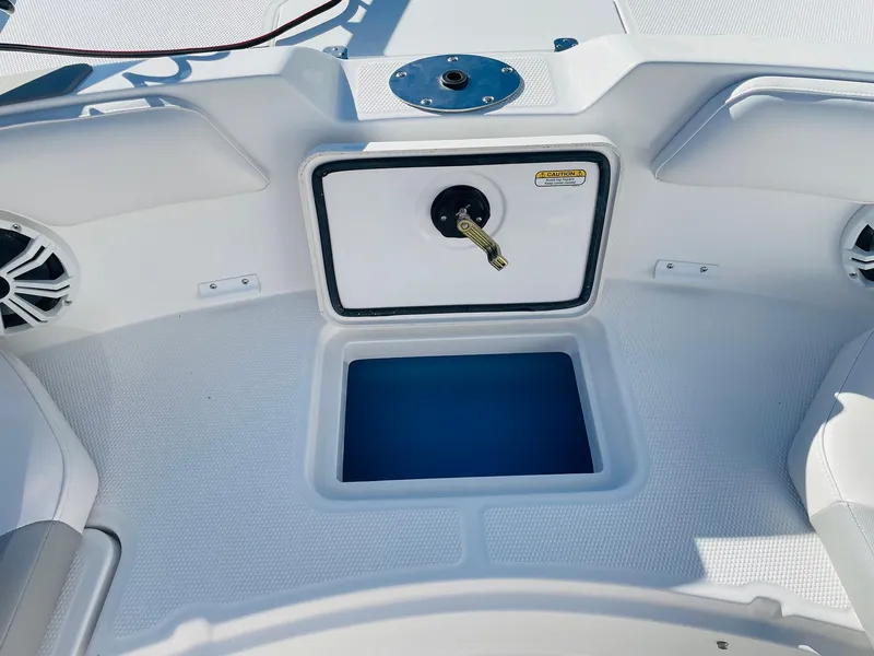 Slide: The Image of 2024 Tahoe 2150 CC boat interior with storage compartment and seating. - 13