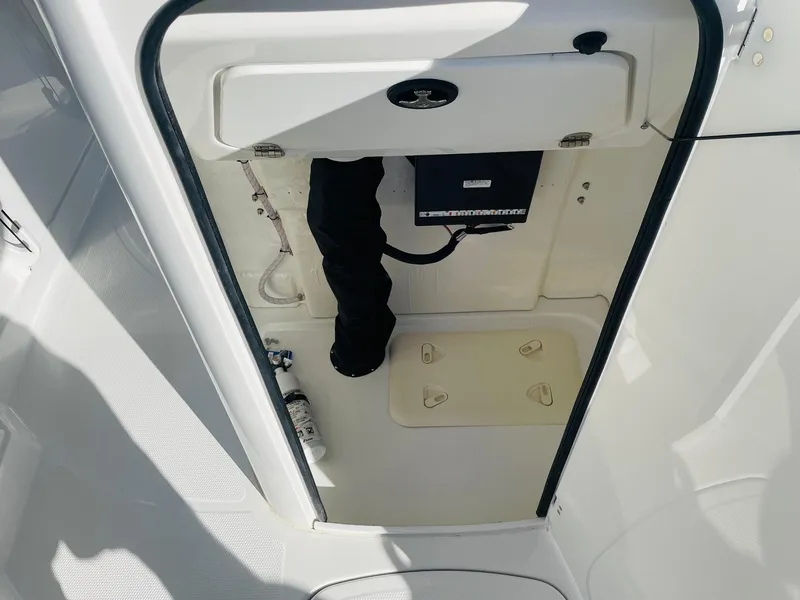 Slide: The Image of 2024 Tahoe 2150 CC boat storage compartment with access panel and wiring. - 19