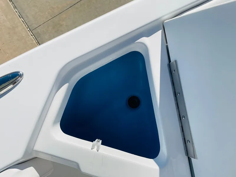 Slide: The Image of 2024 Tahoe 2150 CC boat storage compartment with blue interior. - 24