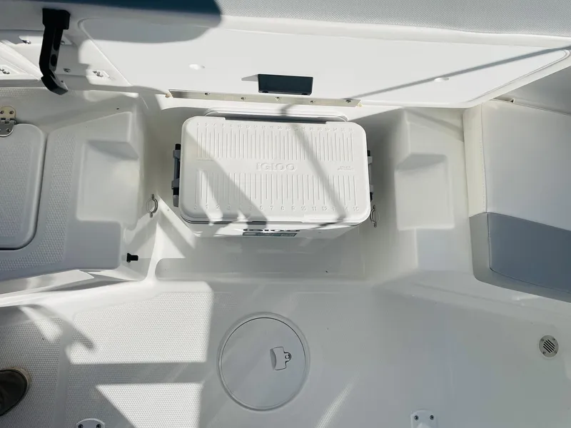 Slide: The Image of 2024 Tahoe 2150 CC boat interior with Igloo cooler and storage compartments. - 36