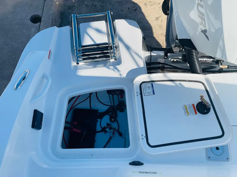 Slide: The Image of 2024 Tahoe 2150 CC boat stern with open storage compartment and ladder. - 39