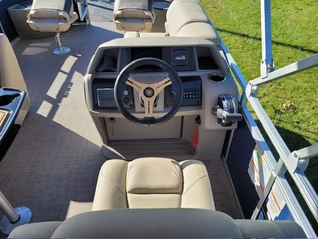 Slide: The Image of 2024 Sun Tracker Fishin' Barge 20 DLX interior with steering wheel and seating. - 3