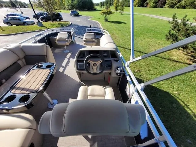Slide: The Image of 2024 Sun Tracker Fishin' Barge 20 DLX interior with helm, seating, and table. - 4