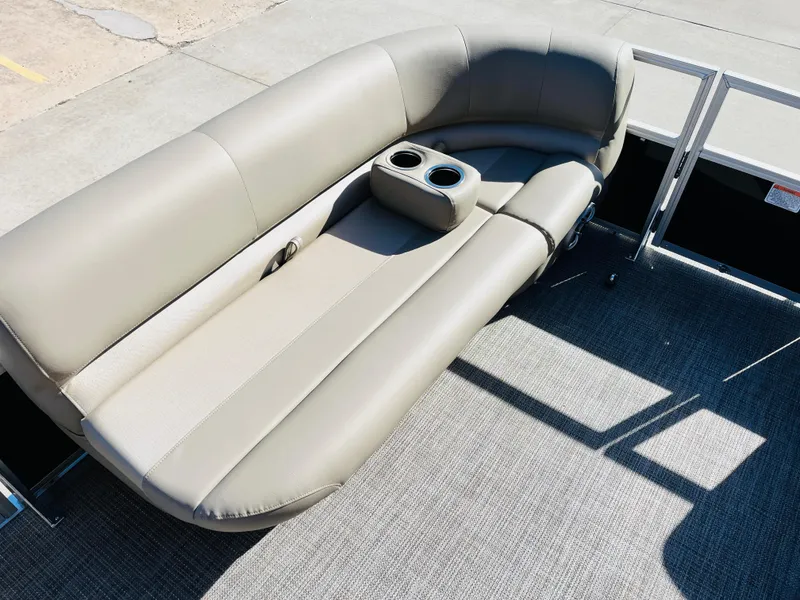 Slide: The Image of 2024 Ranger Reata 200C boat with beige cushioned seating and built-in cup holders. - 16