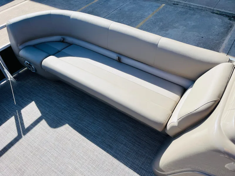 Slide: The Image of 2024 Ranger Reata 200C boat with spacious beige seating area. - 18