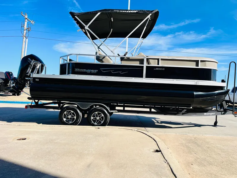 Slide: The Image of 2024 Ranger Reata 200C pontoon boat with black exterior and canopy. - 28