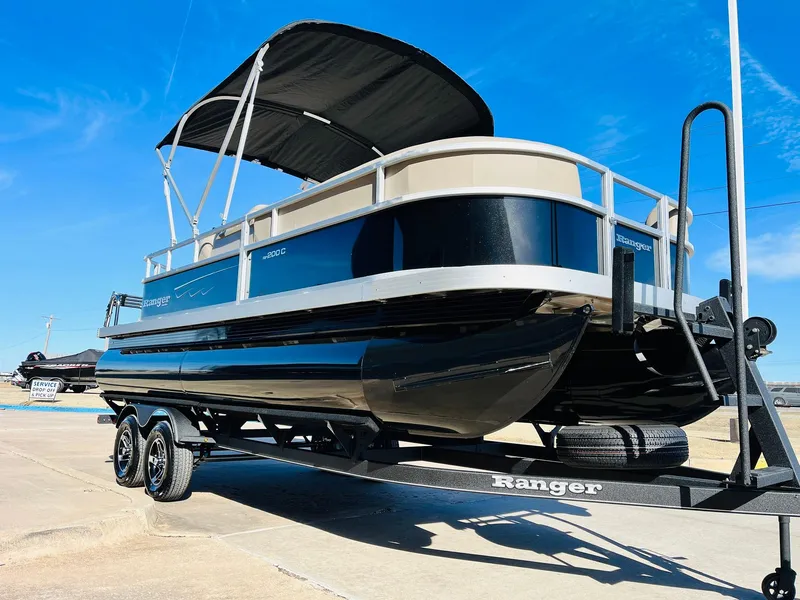 Slide: The Image of 2024 Ranger Reata 200C pontoon boat on a trailer under a clear blue sky. - 33