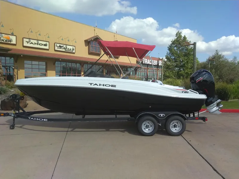 The Image of 2024 Tahoe T21 boat on trailer with red canopy, parked outside dealership. - 0