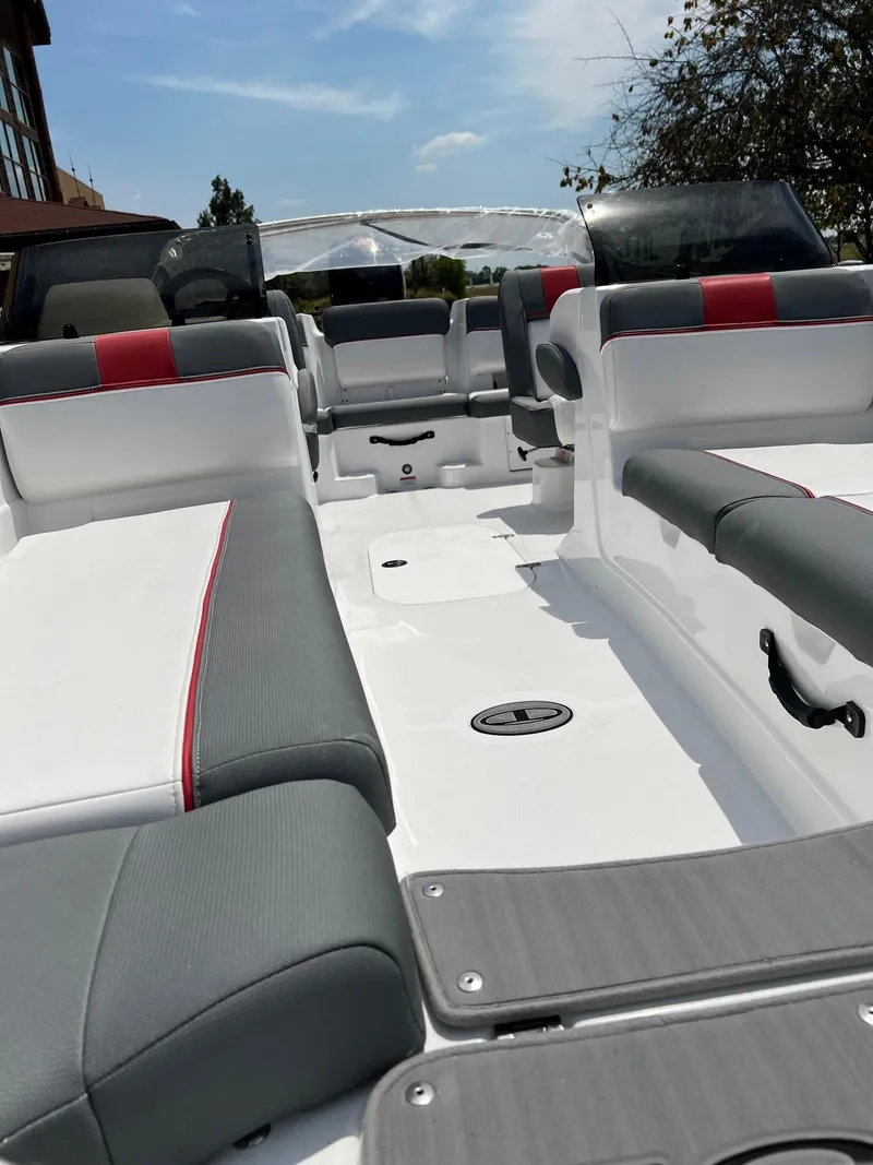 Slide: The Image of 2024 Tahoe T21 boat interior with gray and red seating under a sunny sky. - 3