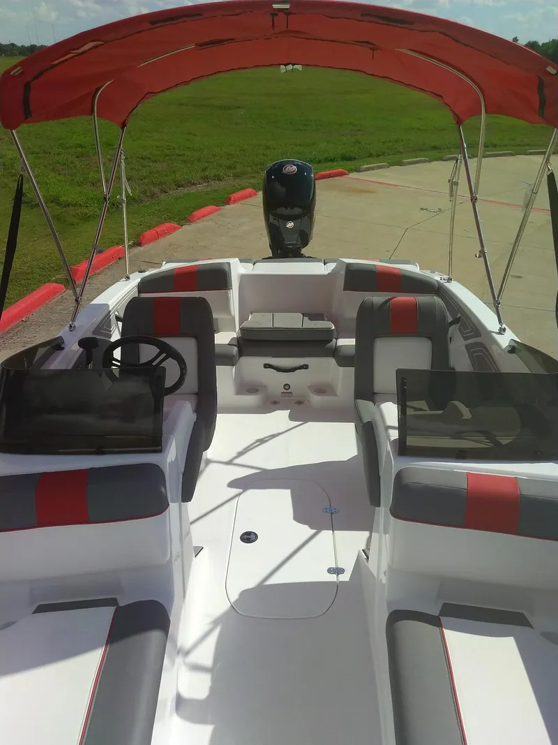 Slide: The Image of 2024 Tahoe T21 boat with red canopy and seating, docked on a sunny day. - 7