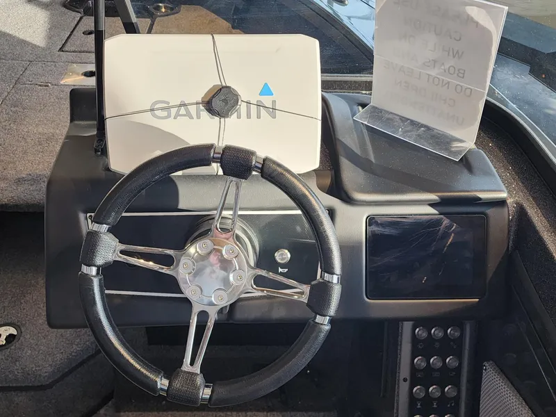 Slide: The Image of 2024 Ranger VX1888 WT boat dashboard with Garmin navigation system and steering wheel. - 2