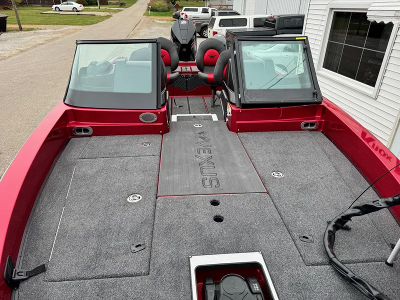 Slide: The Image of 2024 Vexus DVX20S boat, red exterior, spacious deck, dual windshields, parked near a building. - 10