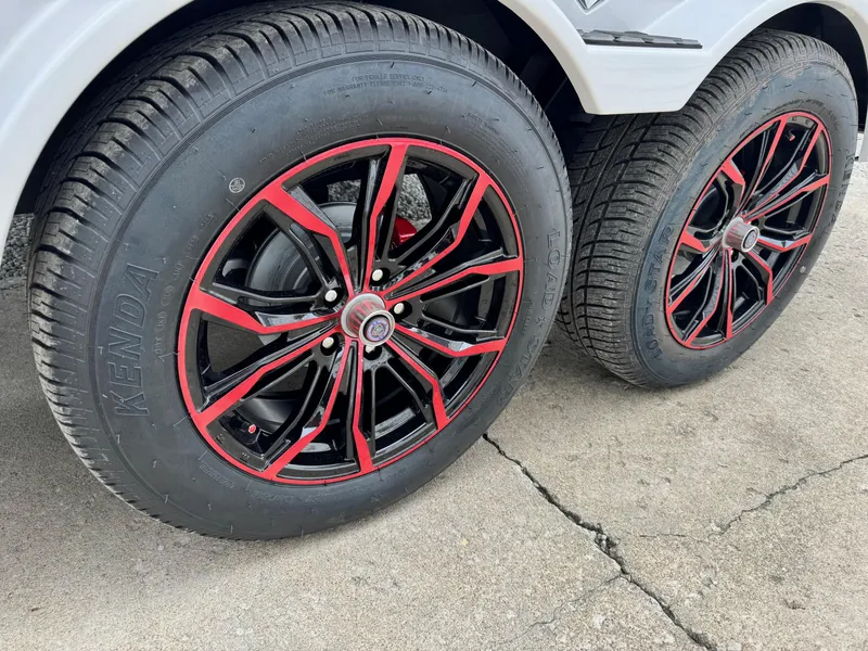 Slide: The Image of 2024 Vexus DVX20S wheels with black and red rims on concrete surface. - 13