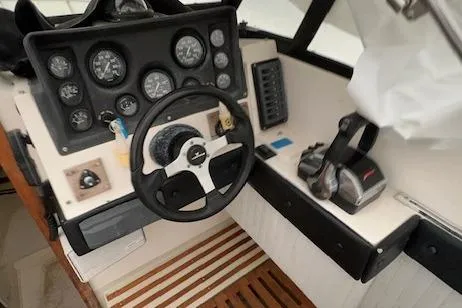 Slide: The Image of 1973 Formula Thunderbird 26 boat dashboard with steering wheel and control gauges. - 6