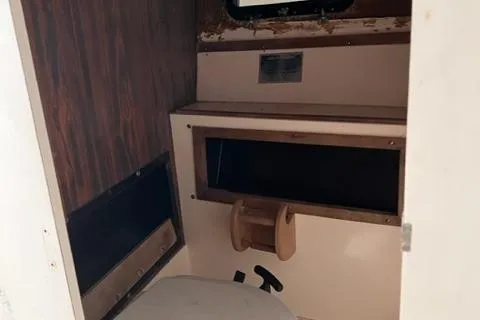 Slide: The Image of Interior of a 1973 Formula Thunderbird 26 boat, featuring a compact bathroom space. - 8
