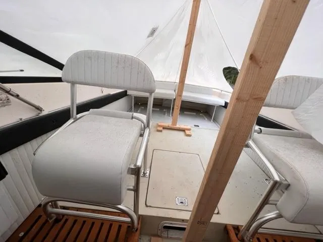 Slide: The Image of 1973 Formula Thunderbird 26 boat interior with white seating and wooden flooring. - 9