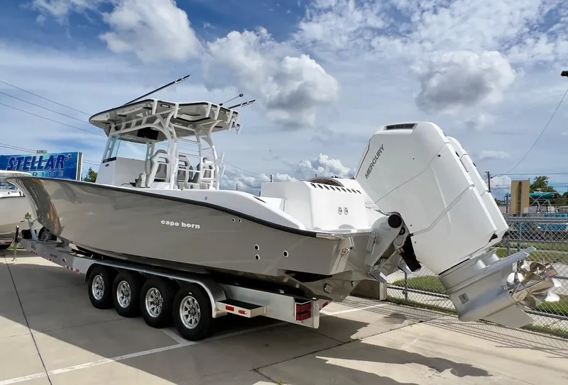Slide: The Image of 2025 Cape Horn 39 T boat on trailer, featuring powerful outboard engines, under a partly cloudy sky. - 3