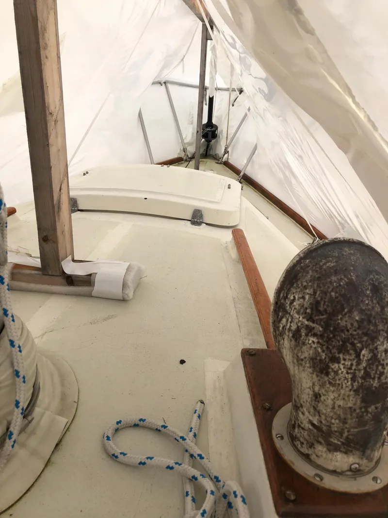 Slide: The Image of 1976 Tartan 30 sailboat deck with ropes and fittings under a tarp. - 13