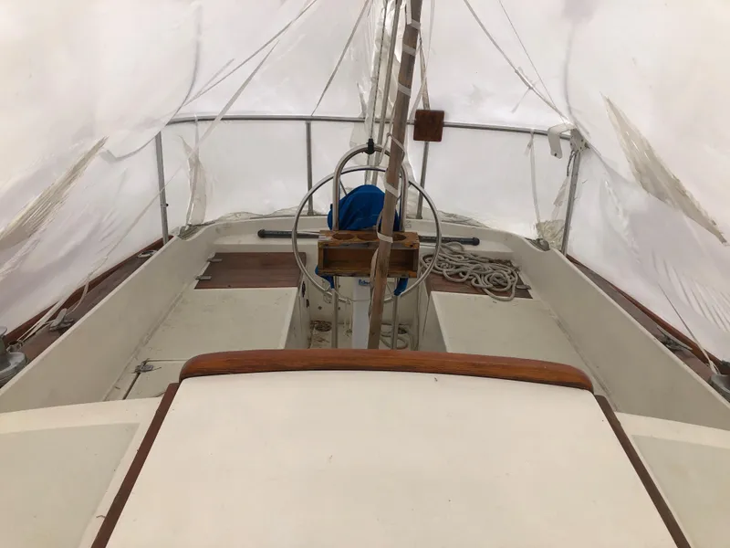 Slide: The Image of 1976 Tartan 30 sailboat cockpit with steering wheel, ropes, and covered deck. - 14