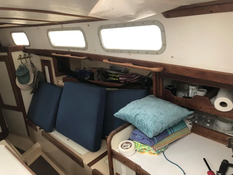 Slide: The Image of 1976 Tartan 30 sailboat interior with cushions, storage, and nautical decor. - 19
