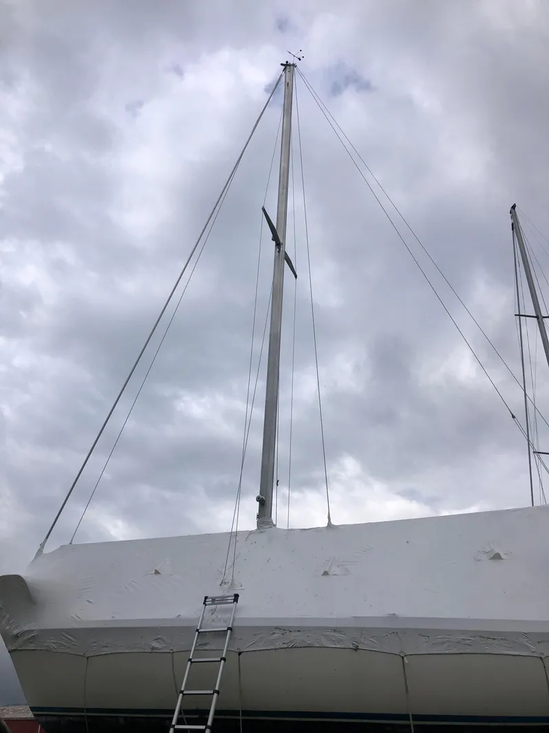 Slide: The Image of 1976 Tartan 30 sailboat with mast and ladder under cloudy sky. - 2