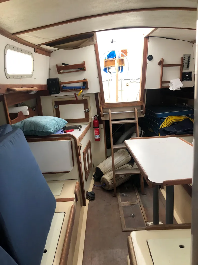 Slide: The Image of 1976 Tartan 30 sailboat interior with seating, table, and nautical equipment. - 25