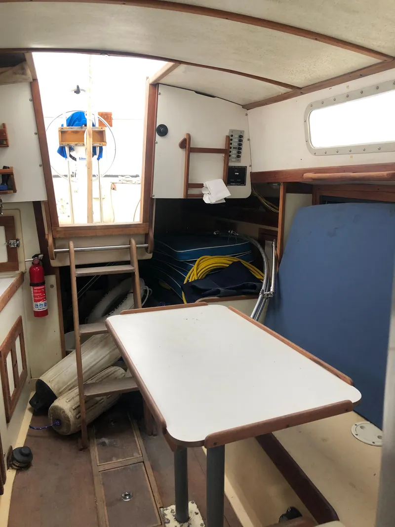 Slide: The Image of Interior of a 1976 Tartan 30 sailboat with table, ladder, and nautical equipment. - 26