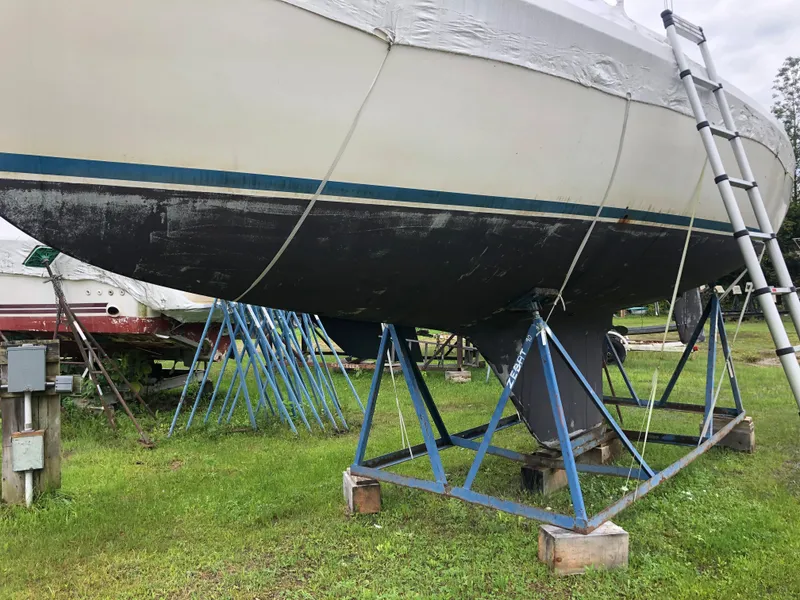 Slide: The Image of 1976 Tartan 30 sailboat on stands, with a ladder, on grassy area. - 3