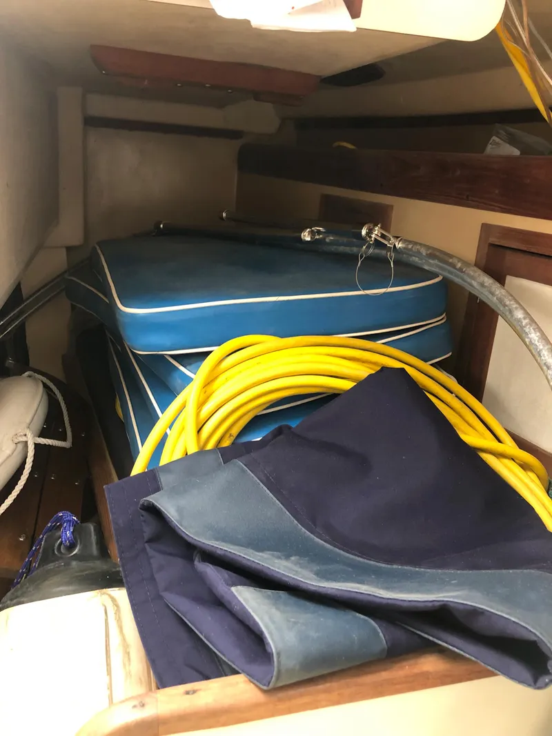 Slide: The Image of Interior of 1976 Tartan 30 sailboat with cushions, yellow rope, and folded fabric. - 30