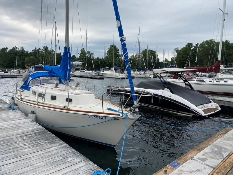 Slide: The Image of 1976 Tartan 30 sailboat docked at marina, overcast sky, surrounded by other boats. - 34