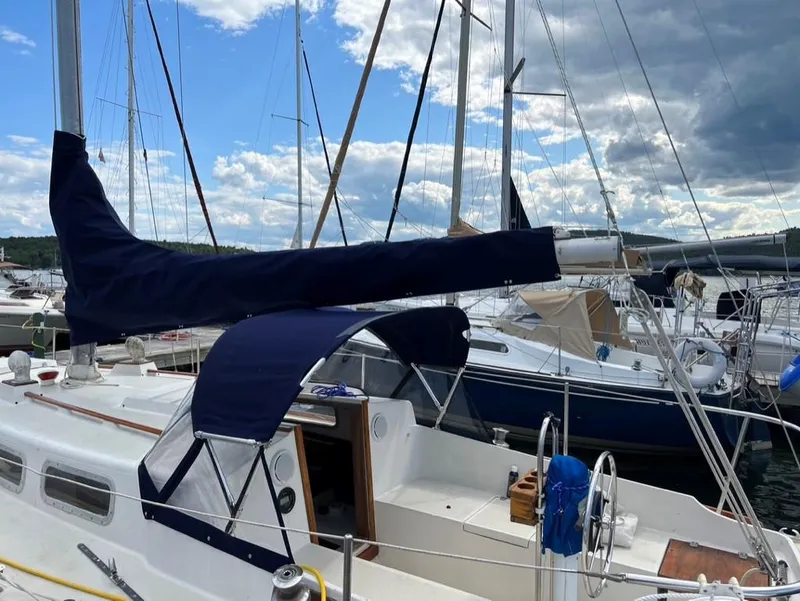 Slide: The Image of 1976 Tartan 30 sailboat docked at marina under cloudy sky. - 35