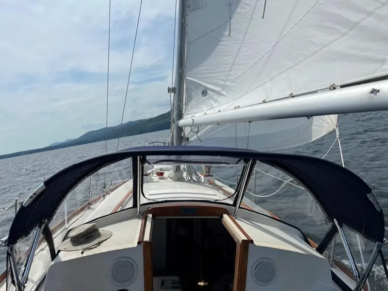 Slide: The Image of 1976 Tartan 30 sailboat on open water, featuring sails and cockpit view. - 36