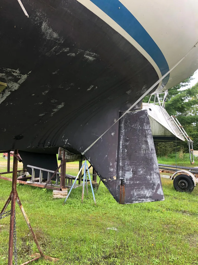 Slide: The Image of 1976 Tartan 30 sailboat hull and rudder on stands, grassy yard background. - 5