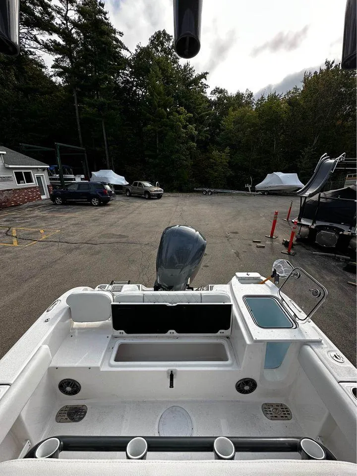 Slide: The Image of 2024 Sea Fox 248 Commander boat interior with motor, parked outdoors. - 10