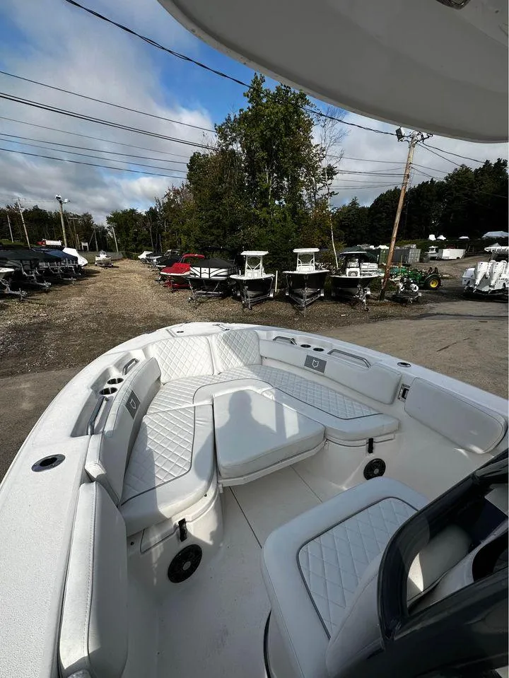 Slide: The Image of 2024 Sea Fox 248 Commander boat with spacious seating, parked outdoors under a cloudy sky. - 3
